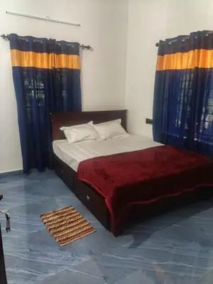 a bedroom with a bed with blue and orange curtains at Sandal Homestay in Marayoor