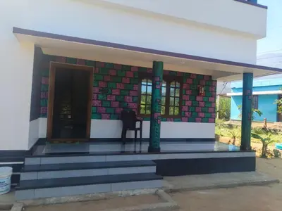 a house with a staircase leading to the front door at Sandal Homestay in Marayoor