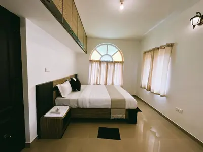 a bedroom with a large bed with a window at Hestia chalet 3BHK near Ooty lake in Ooty