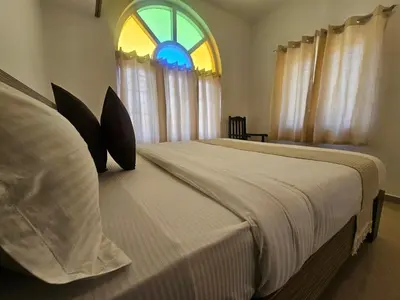 a bedroom with a large bed with a window at Hestia chalet 3BHK near Ooty lake in Ooty