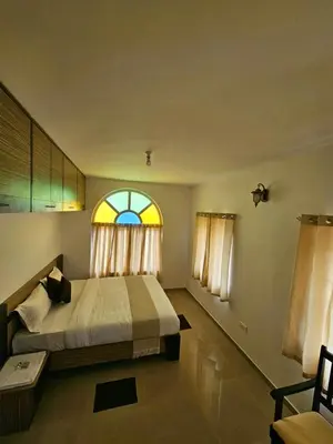 a bedroom with a bed and a window at Hestia chalet 3BHK near Ooty lake in Ooty