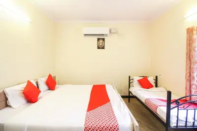 a bedroom with two beds with red and white pillows at Hotel O Kingston Residency in Vānivilāsa Puram