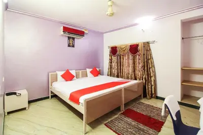 a bedroom with a bed with red pillows at Hotel O Kingston Residency in Vānivilāsa Puram