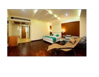 a living room with a bed and a couch at Hotel Vijay Elanza in Coimbatore