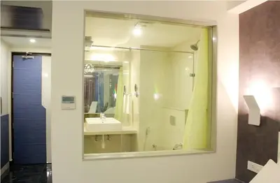 a bathroom with a mirror and a sink at Hotel Vijay Elanza in Coimbatore