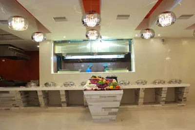 a restaurant with a counter in a room with lights at Hotel Vijay Elanza in Coimbatore