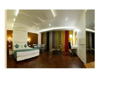 a living room with a bed and a couch in it at Hotel Vijay Elanza in Coimbatore