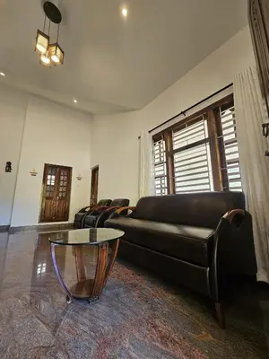 a living room with a leather couch and a table at Serene Villa in Koroth
