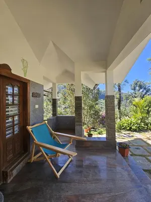 a lounge chair on the porch of a house at Serene Villa in Koroth