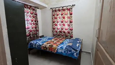 a small bedroom with a bed and curtains at Happy Home Stay in Palakkad