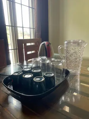 a tray of cups and a vase on a table at VR cottage in Ooty