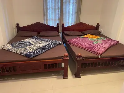 two beds sitting next to each other in a room at VR cottage in Ooty