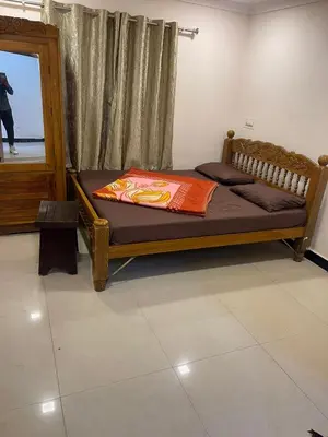 a bedroom with a wooden bed and a window at VR cottage in Ooty