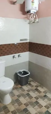 a bathroom with a toilet and a bowl on the floor at Essaar Punnot Farmstay Resort in Kollengode