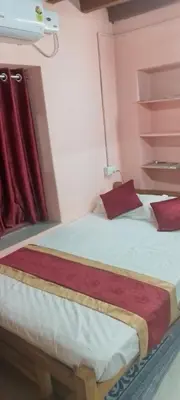 a bedroom with a large bed with red pillows at Essaar Punnot Farmstay Resort in Kollengode