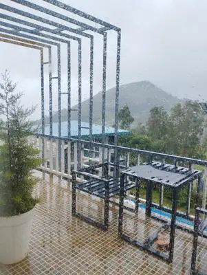 a rain soaked balcony with a table at Viharana Spa and Resorts in Ooty