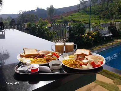 a tray of breakfast food on a table next to a pool at Viharana Spa and Resorts in Ooty