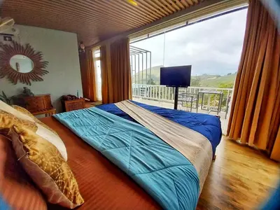 a bedroom with a bed and a large window at Viharana Spa and Resorts in Ooty