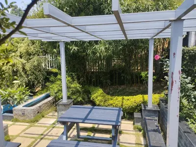 a blue picnic table under a white pergola at Viharana Spa and Resorts in Ooty