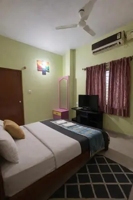 a bedroom with a large bed and a television at Casa Mysuru Boulevard Stay Cozy 2BHK AC in Mysore