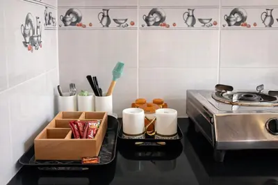 a kitchen with a stove and a tray with utensils at Casa Mysuru Boulevard Stay Cozy 2BHK AC in Mysore
