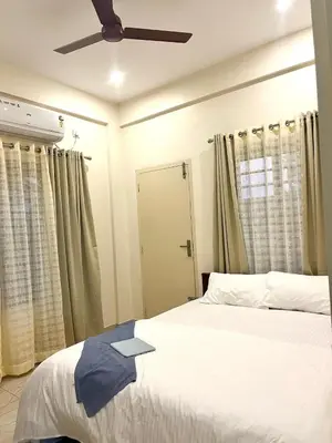a bedroom with a bed and a ceiling fan at Serenity Homes near Rajagiri Hospital in Alwaye