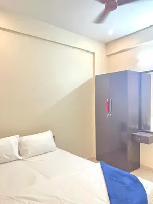 a bedroom with a white bed and a glass wall at Serenity Homes near Rajagiri Hospital in Alwaye