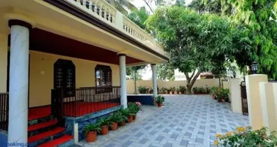 a building with stairs and plants in a courtyard at Hamai town villa in Ambalavayal