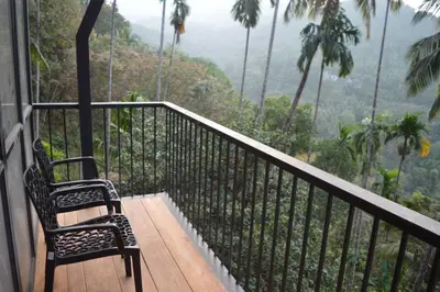 a balcony with a chair and a view of the mountains at Waterfall View Stay Chappanthotam Kozhikode in Kuttyādi