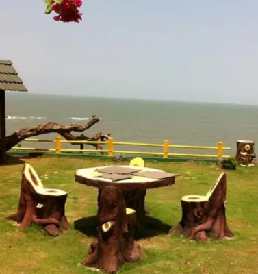 a table and two chairs and a table and a table and some water at Razena Beach in Green Island