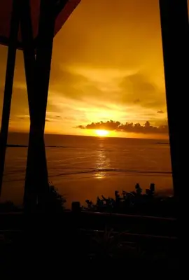 a sunset view from a hotel room looking out at the ocean at Razena Beach in Green Island