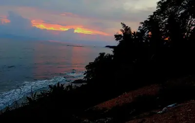 a sunset over the ocean with the sky at Razena Beach in Green Island