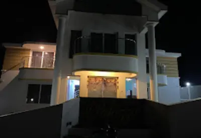 a large white house at night with its lights on at Palazzo Villa in Ooty
