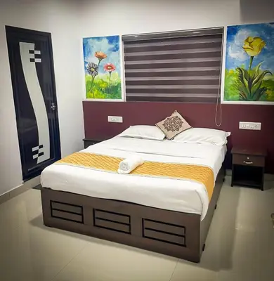 a bed in a bedroom with a painting on the wall at Edakkal Pool Villa in Ambalavayal