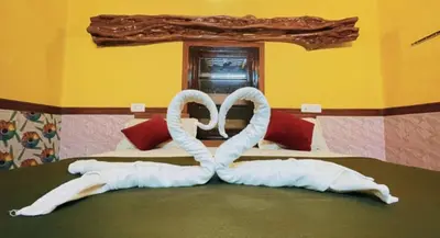 a bed with two swans made out of towels at Pepper Valley Resort in Kalpetta