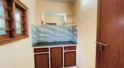 a kitchen with a counter top and a mirror at Pepper Valley Resort in Kalpetta