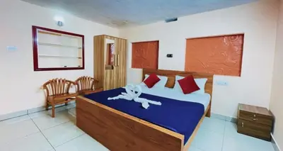 a bedroom with a bed and a chair in it at Pepper Valley Resort in Kalpetta