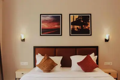 a bedroom with a bed with four pictures on the wall at Coorg Homes in Madikeri