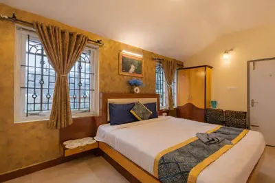 a bedroom with two beds and a window at Pentoz Hotels Boutique Stay Near Botanical Garden Ooty in Ooty
