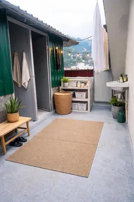 an outdoor area with a rug on a balcony at Pentoz Hotels Boutique Stay Near Botanical Garden Ooty in Ooty