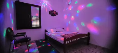 a purple room with a bed with lights on it at Krishna stays in Manattala