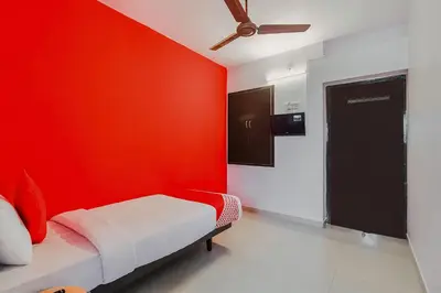 a red room with a bed with a red wall at Super Hotel O By OYO Maruthi Gandhi Park in Coimbatore