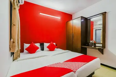 a red bedroom with a bed with red pillows at Super Hotel O By OYO Maruthi Gandhi Park in Coimbatore