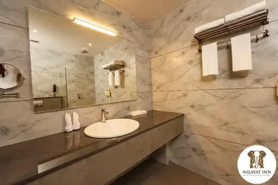 a bathroom with a sink and a mirror at Nilayat Inn in Ollur