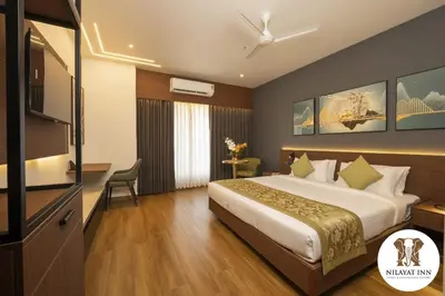 a hotel room with a bed and a television at Nilayat Inn in Ollur