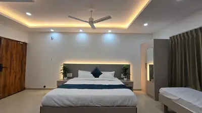 a bedroom with a large bed with a ceiling fan at Hi-Fi Service Apartment in Mysore