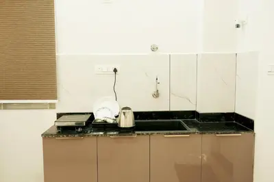 a kitchen with white walls and a counter top at Hi-Fi Service Apartment in Mysore