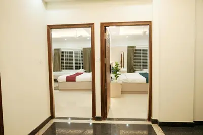 a room with two mirrors and two beds at Hi-Fi Service Apartment in Mysore