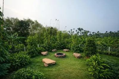 a garden with a fire pit in the grass at Manayath Wayanad Premium Pool Resort in Wayanad