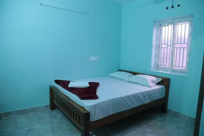 a bedroom with a bed with a blue light on it at Thulir Homestay Valparai in Vālpārai